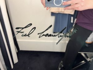 The words "Feel Beautiful" are displayed on a fitting room mirror.